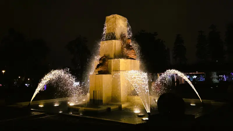 Detalle de las esculturas de piedra y caidas de agua iluminadas en la fuente de los indios de Lima.