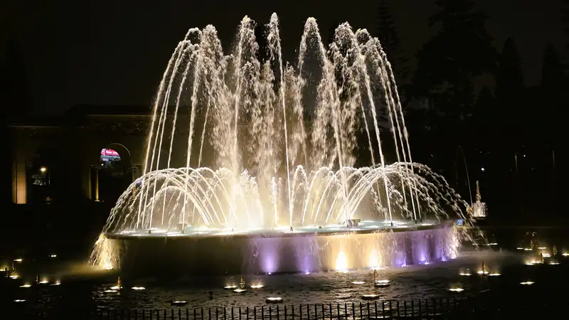 Corona de agua central y luces calidas de la Fuente Magica ornamental en el centro de Lima Peru.