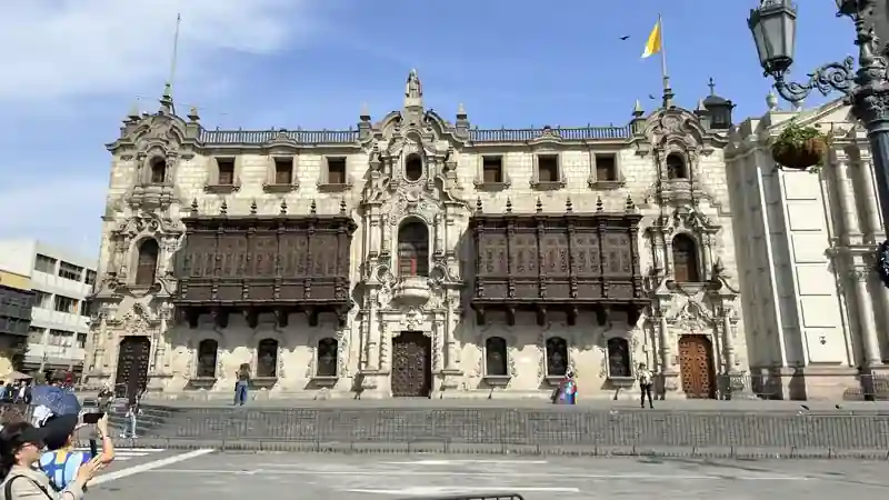 Detalle de los balcones de madera de estilo barroco del Palacio Arzobispal de Lima bajo un cielo despejado.