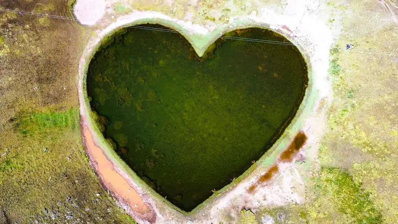 Increible formacion natural de laguna con silueta de corazon verde en el circuito de aventura en cuatrimotos Cusco.