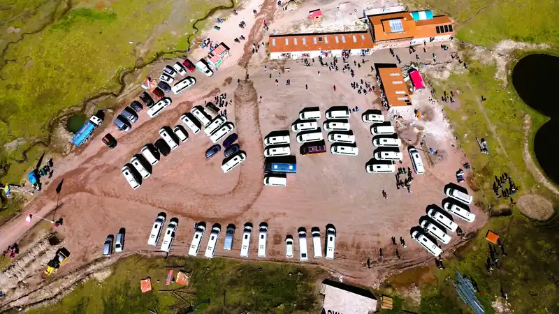 Campamento base con minivan turisticas e infraestructura de recepcion para los viajeros que visitan la montana Vinicunca.