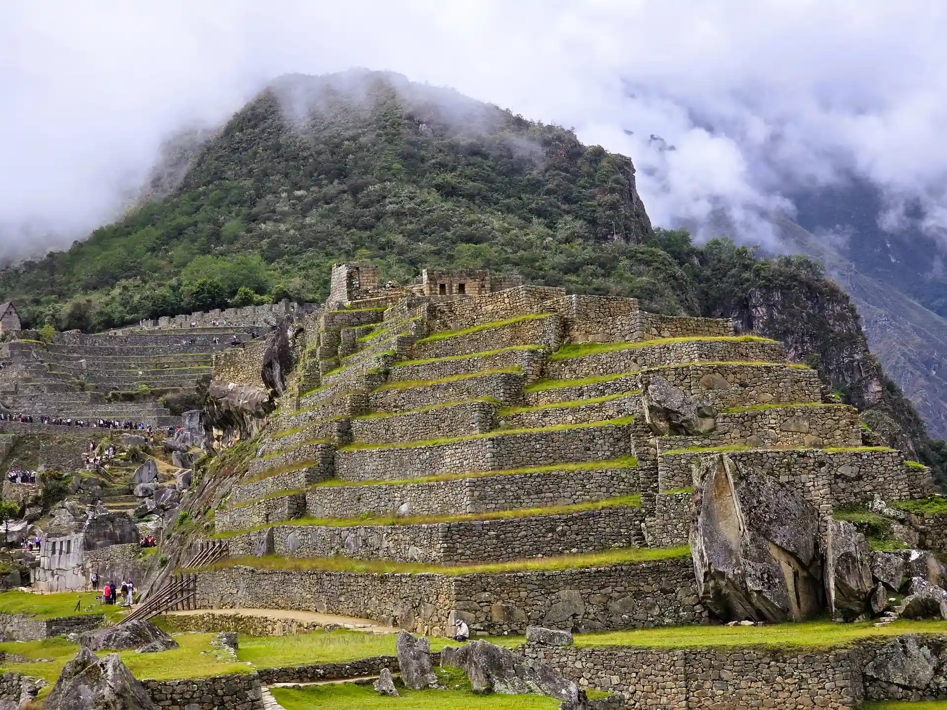 Turistas recorriendo los senderos junto a las milenarias construcciones de piedra en Machu Picchu.