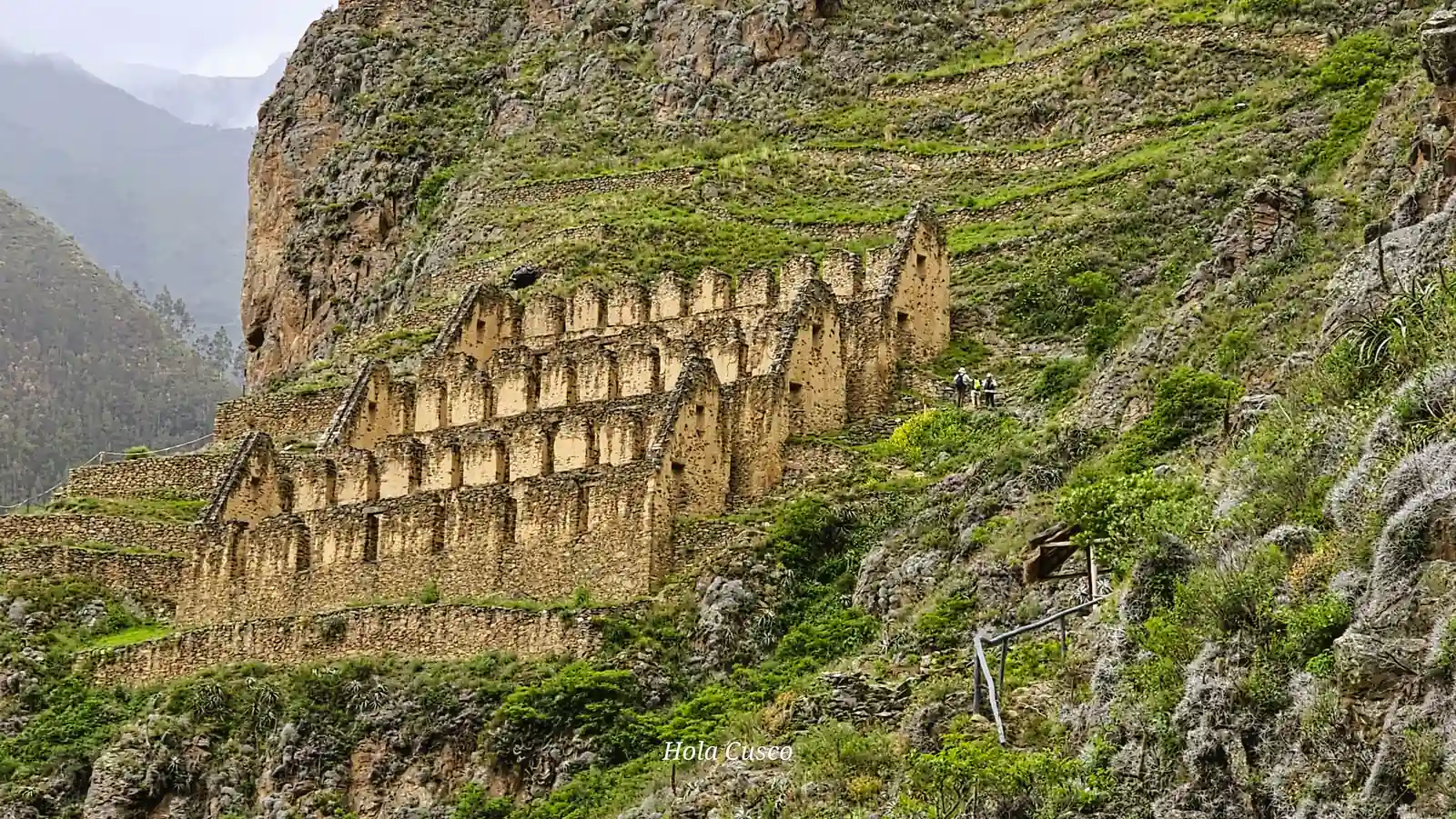 Turistas recorriendo los senderos frente a los almacenes arqueológicos de Pinkuylluna en el Valle Sagrado.